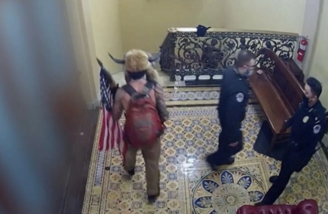 Capitol surveillance video shows ‘QAnon Shaman’ being escorted through building by police, not ‘leading an insurrection